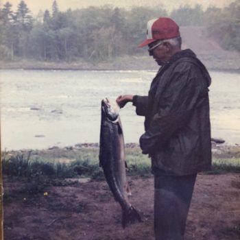 photo of elderly man hold large salmon